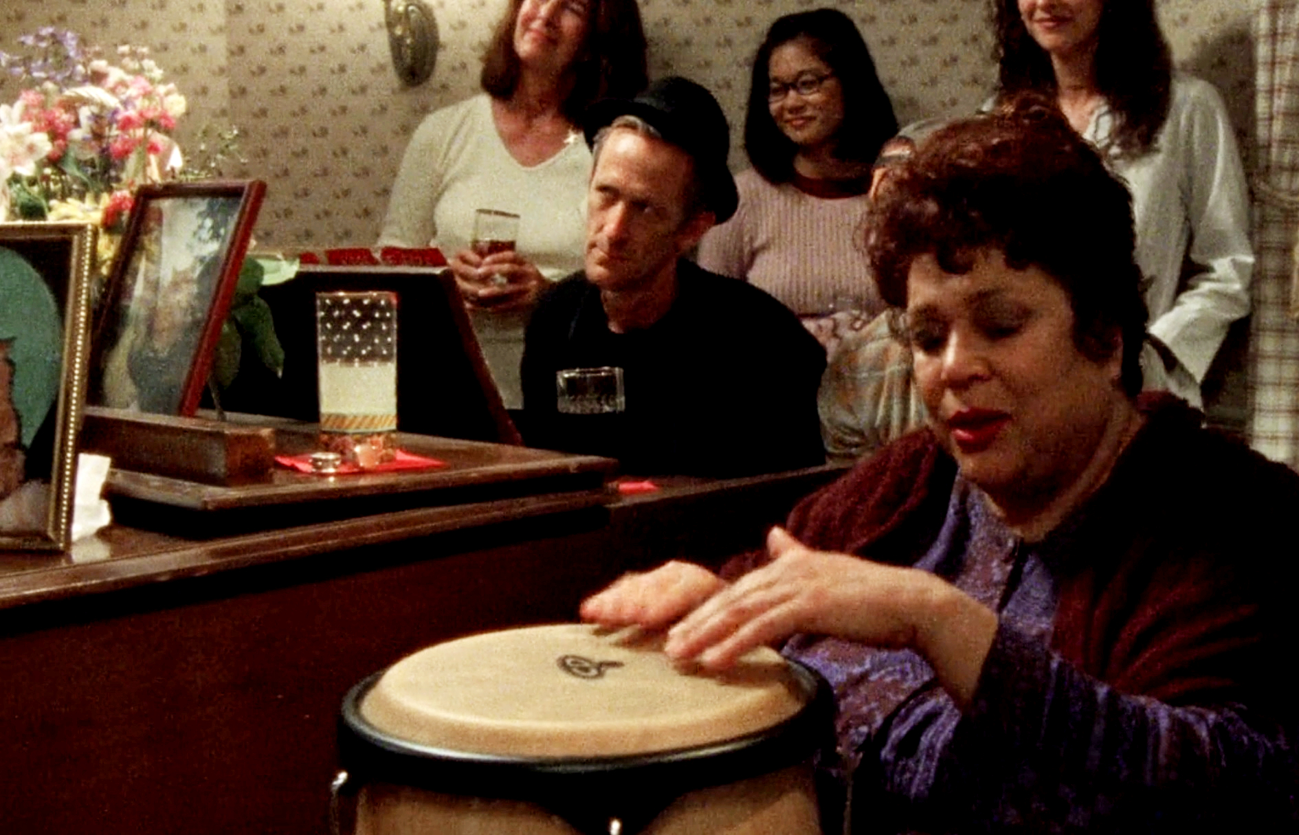 Morey playing piano with everyone huddling around him